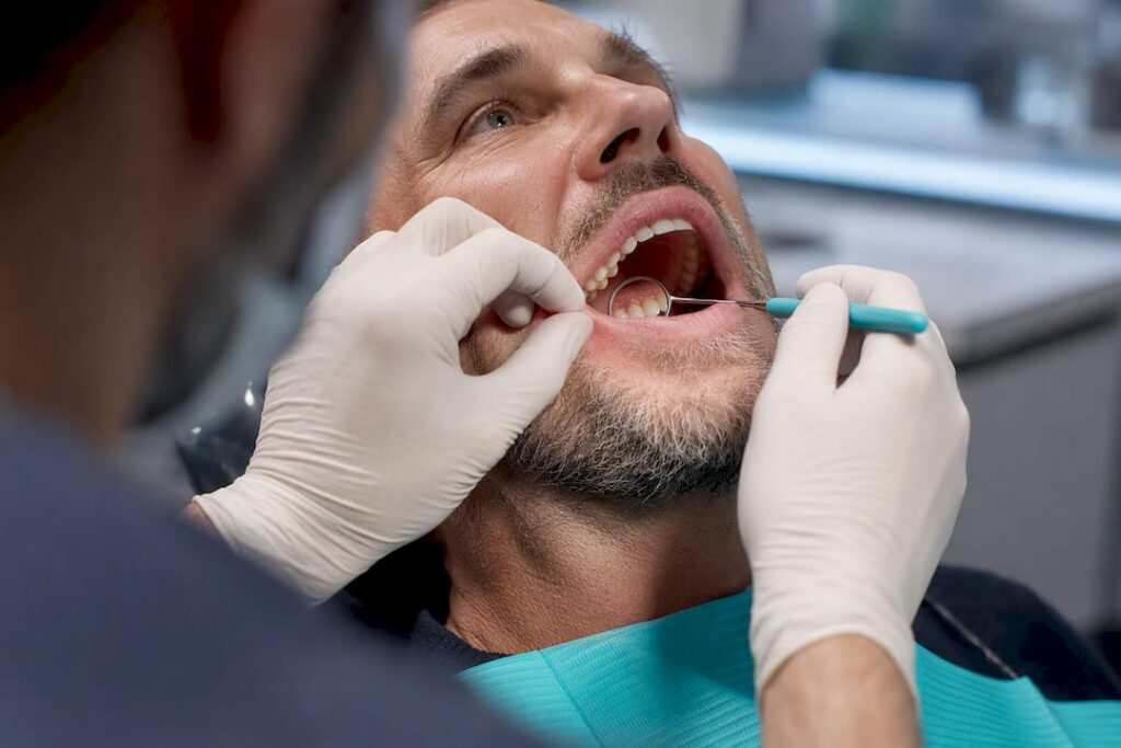Clinician examining gums affected by tobacco exposure