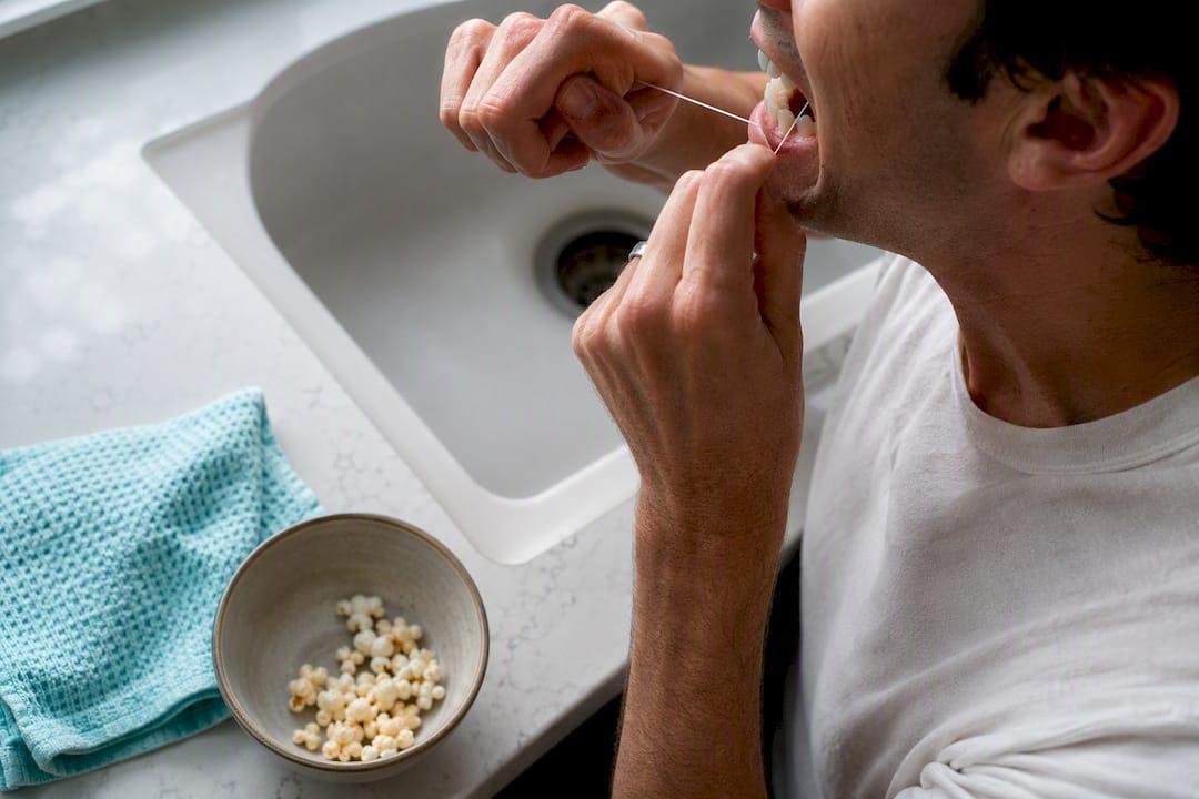 Hands flossing after eating popcorn