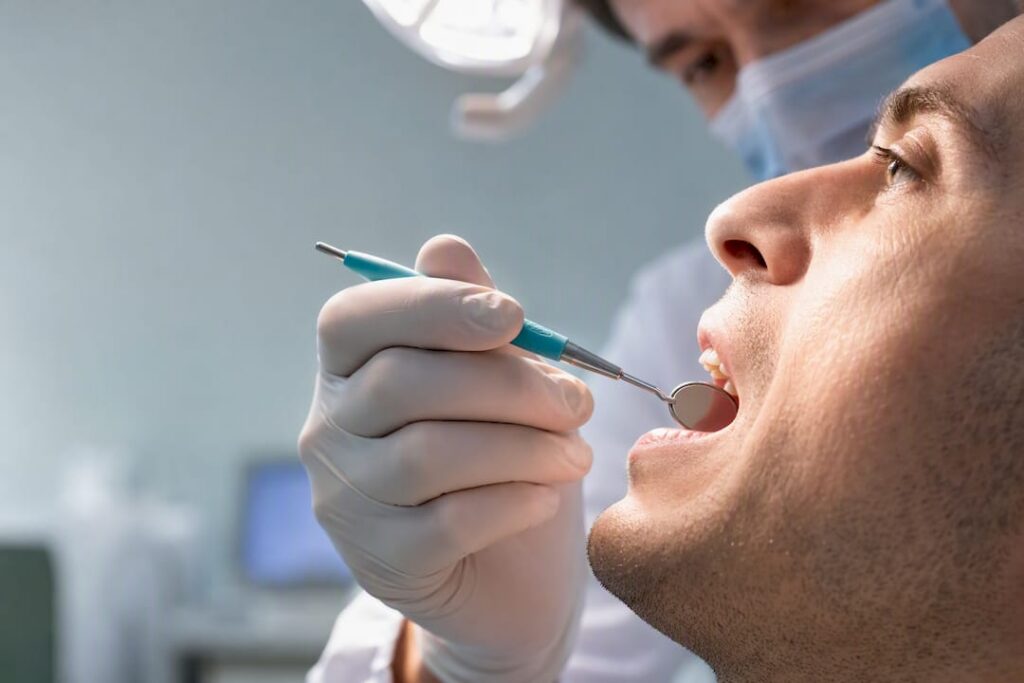 Dentist examining an adult loose tooth