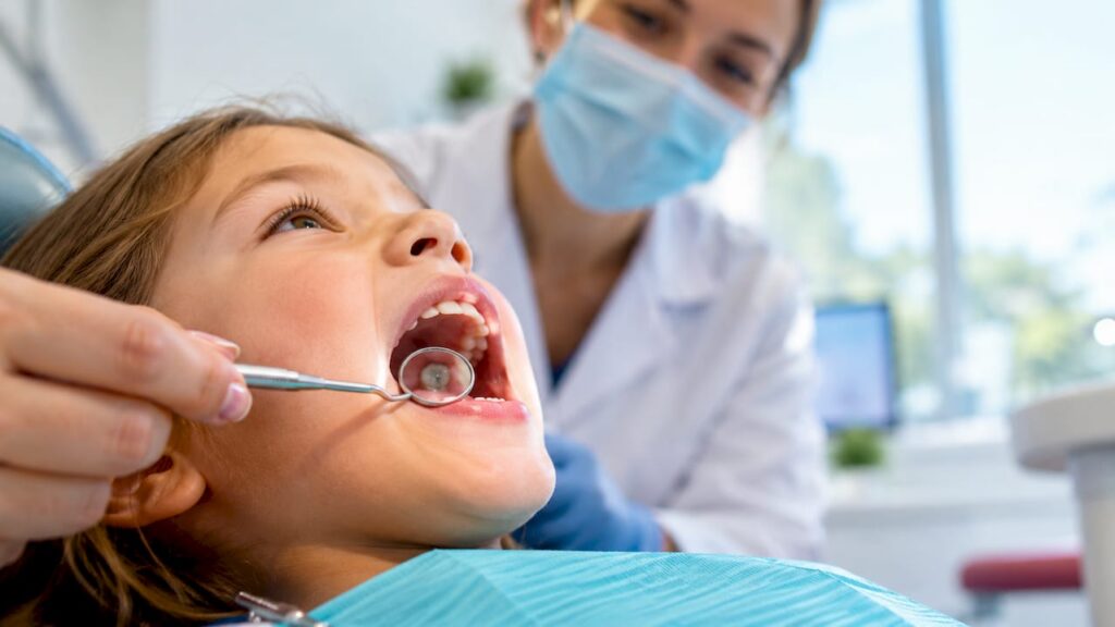 Child with gray tooth during dental exam